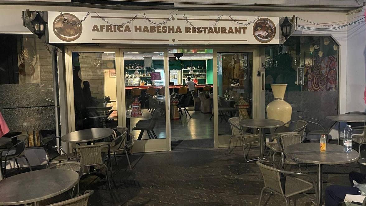 De gevel van Africa Habesha Restaurant aan de Doctor Poelsstraat, met de naam op de luifel en tafeltjes op het terras ervoor.